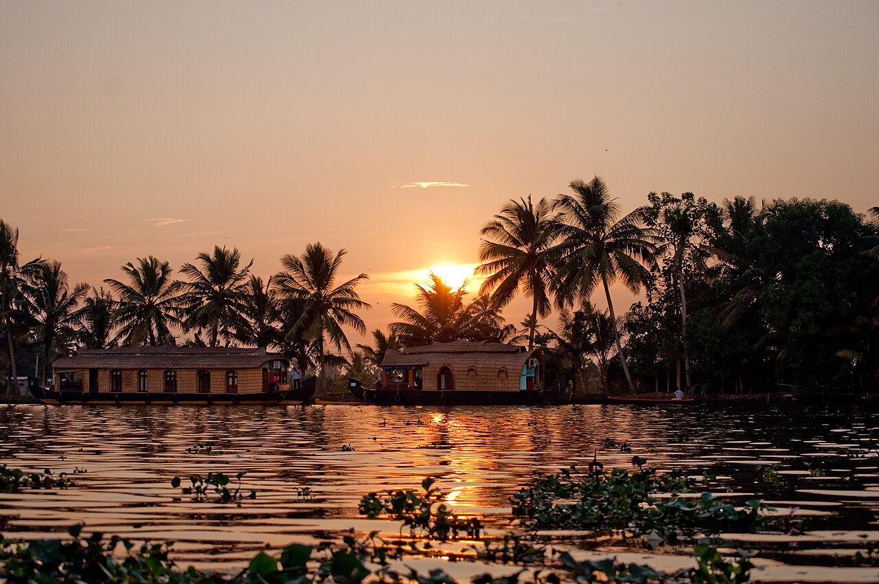 Sunset over houseboats and palm trees on the Alappuzha backwaters
